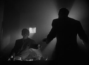 Citizen Kane still: Thompson (William Alland) and Rawlston (Philip Van Zandt) in screening room.