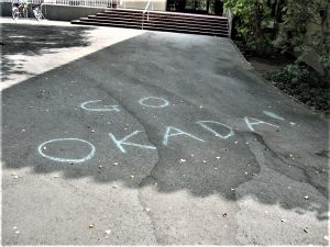 "Go Okada" written in chalk outside the Stanford University Art Building, first day of school (2003).