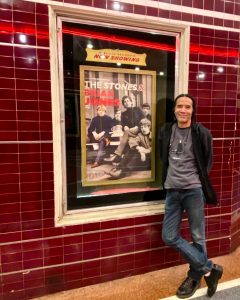 Corey Okada with The Stones & Brian Jones poster; Tower Theater, Sacramento, CA (2023).
